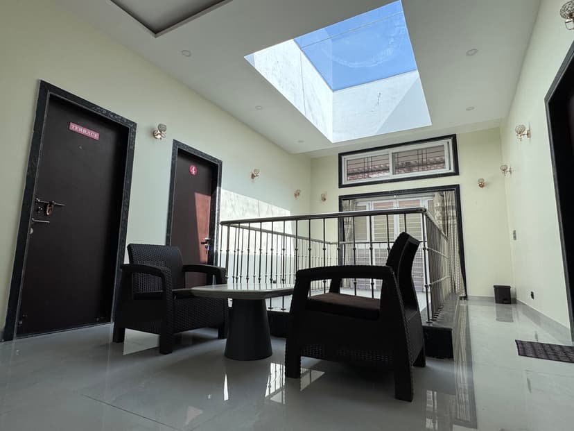Indoor common seating area with skylight and black wicker furniture near terrace entrance