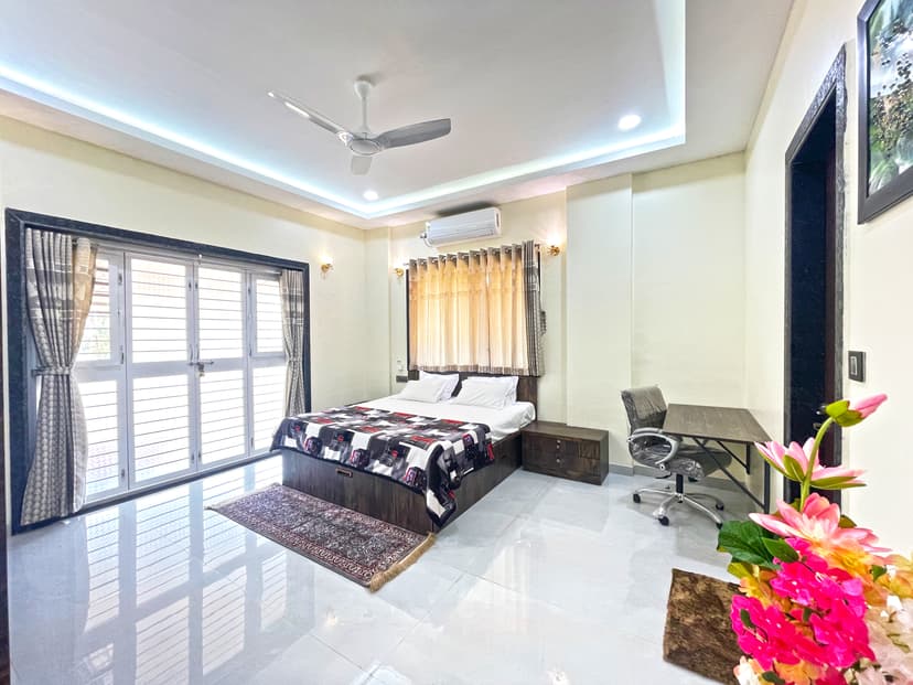 Well-lit bedroom at Kokan Kinara Villa with a study desk and seating area