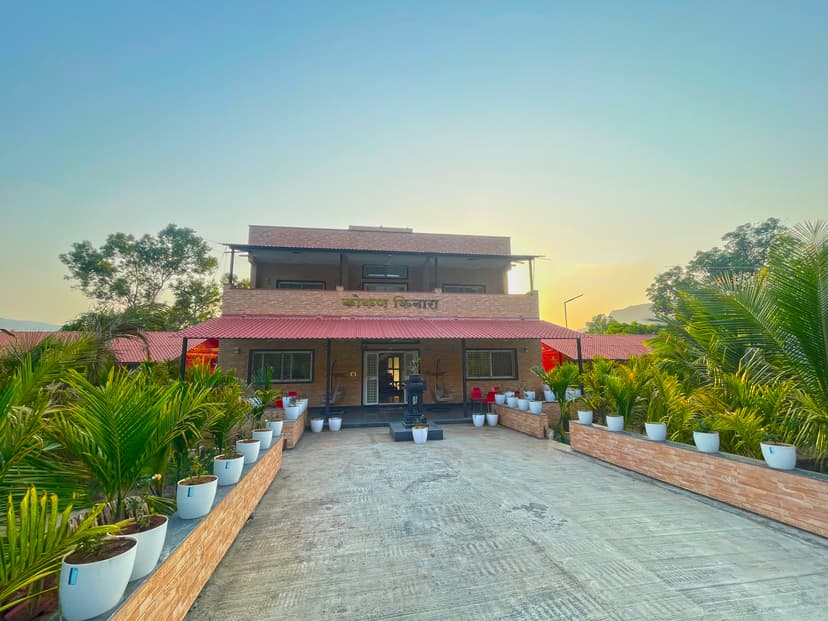 Daytime front entrance of Kokan Kinara Villa with potted plants on both sides