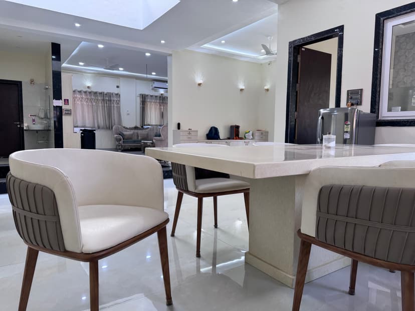 Modern dining area at Kokan Kinara Villa with marble table and cushioned chairs