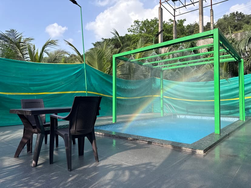 Pool and dining area at Kokan Kinara Villa with elegant outdoor seating and water features