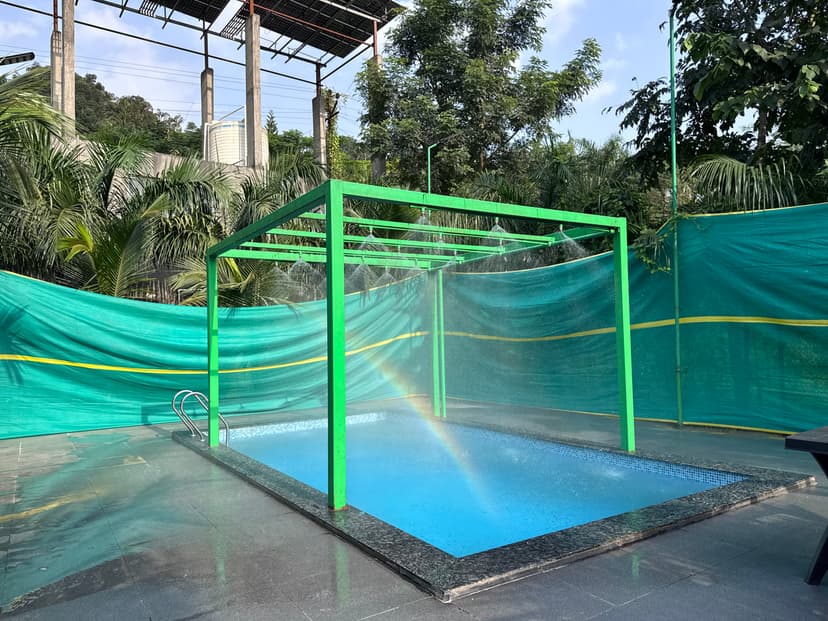 Swimming pool at Kokan Kinara Villa with raindance feature and ambient lighting