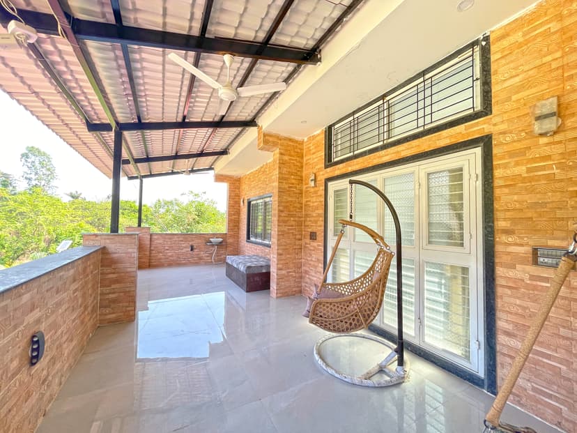 Spacious terrace at Kokan Kinara Villa with a swing chair and sitting area